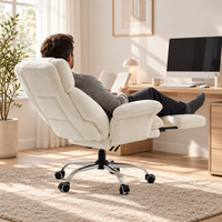 Homme lisant allongé dans le fauteuil inclinable avec les jambes sur le repose-pieds