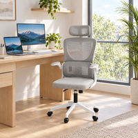 Fauteuil de bureau en maille avec appui-tête devant un bureau en bois dans une pièce lumineuse